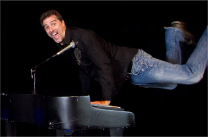 Photo of a happy man leaning on top of the piano