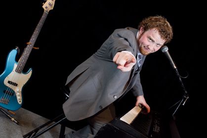 A picture of the man playing the piano with his finger pointing
